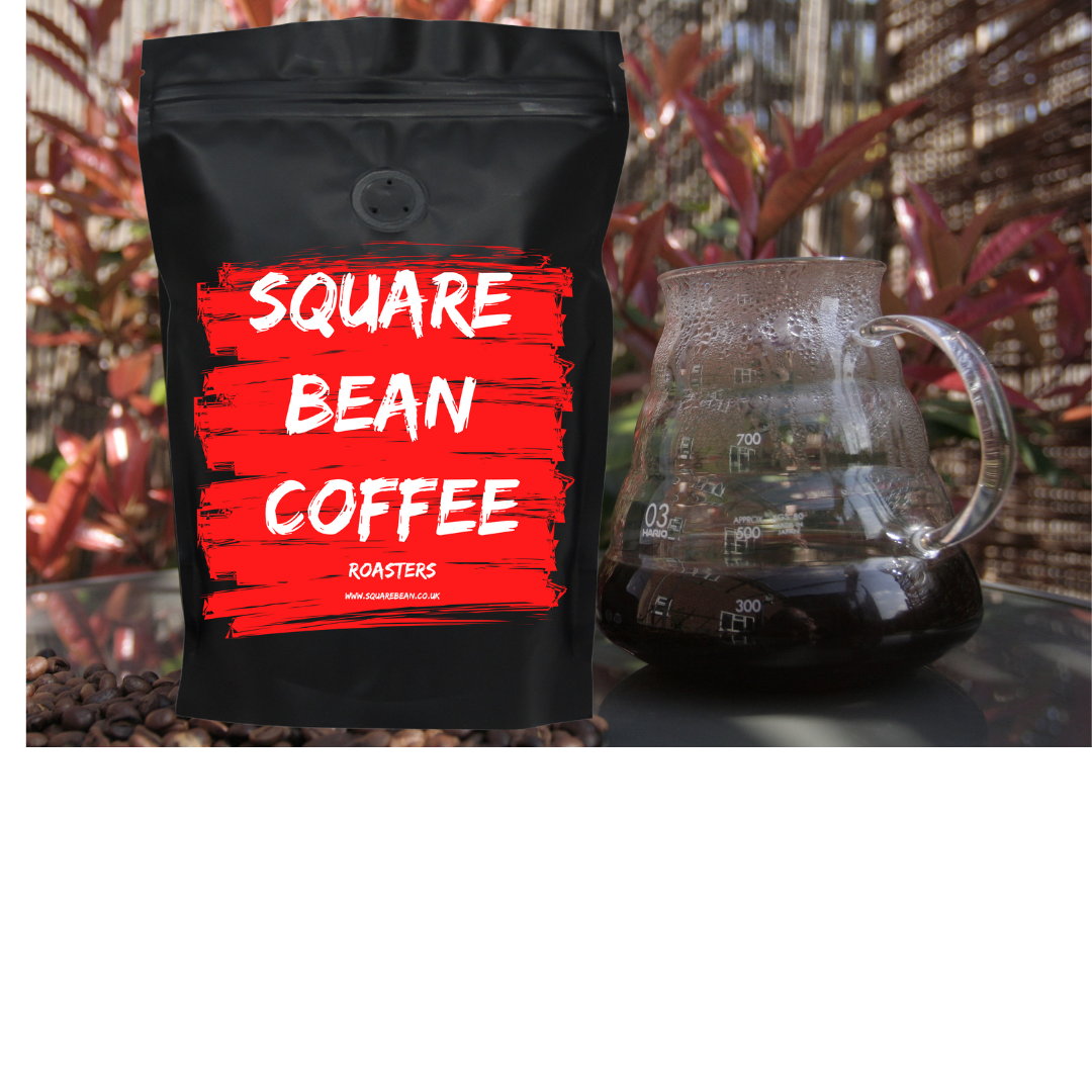 Black coffee bag with red label reading 'Square Bean Coffee' and a glass coffee maker in the background.