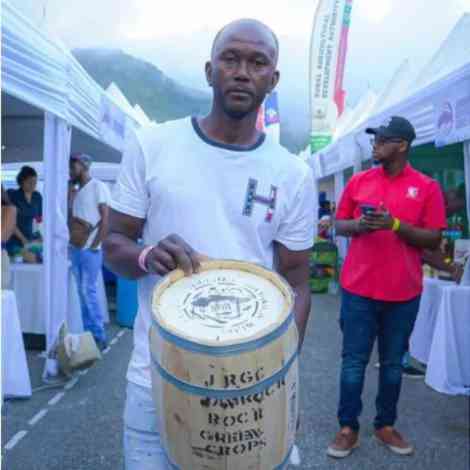 Man holding barrel of authentic Jamaica Blue Mountain Coffee from Pennlyn Estate